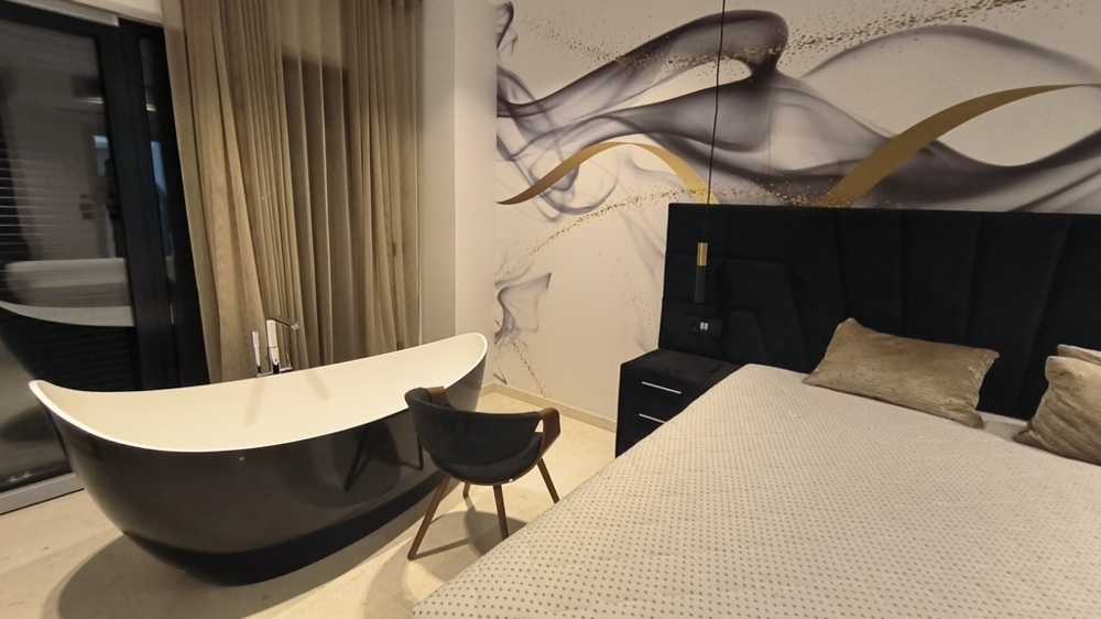 Spálňa s voľne stojacou vaňou a štýlovým dizajnom stien