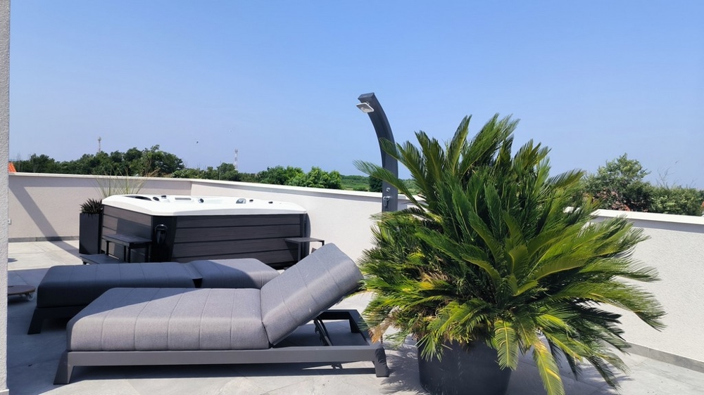 Strešná terasa s ležadlom, vírivkou a výhľadom na krajinu.