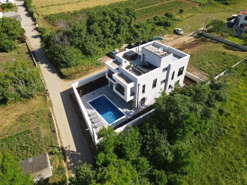 Letecký pohľad na luxusnú vilu s bazénom v zeleni