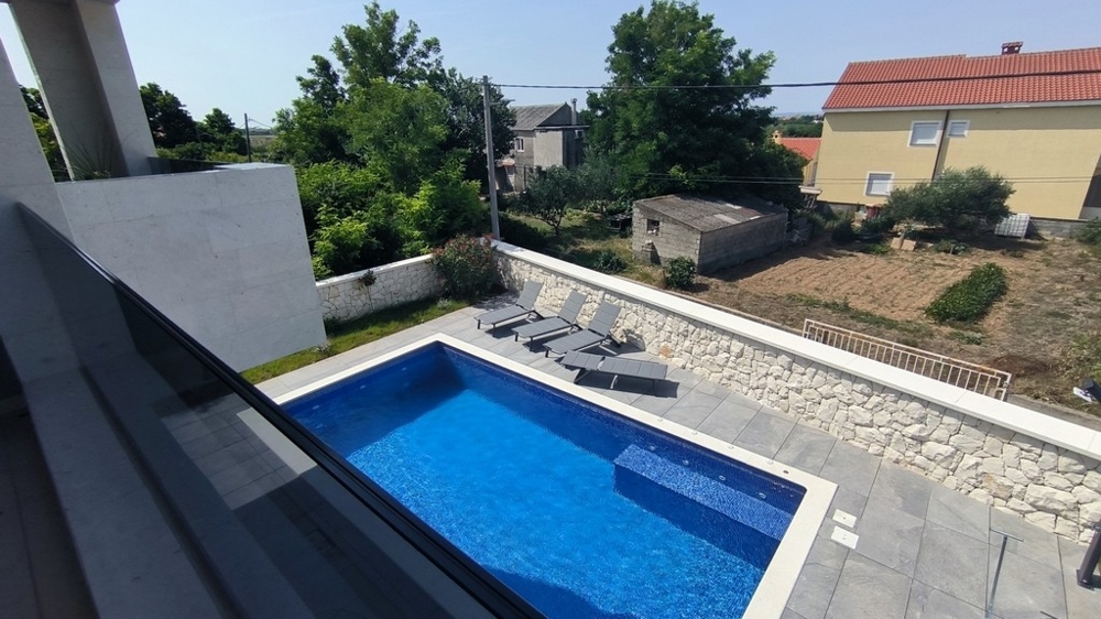 Bazén s ležadlami a stenou z prírodného kameňa