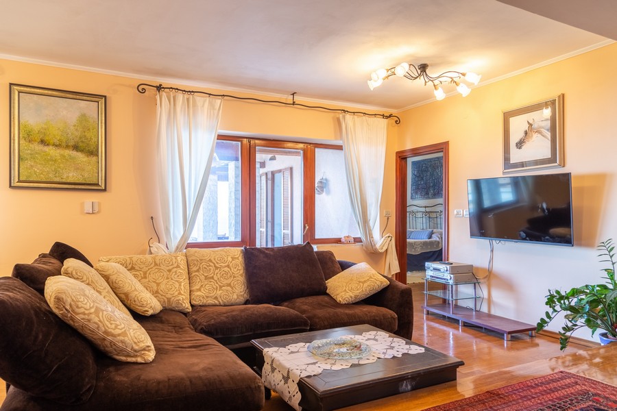 Pekne zariadená obývačka so smart TV na stene.