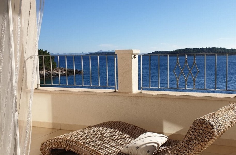 Terasa s výhľadom na more a relaxačným prúteným ležadlom.