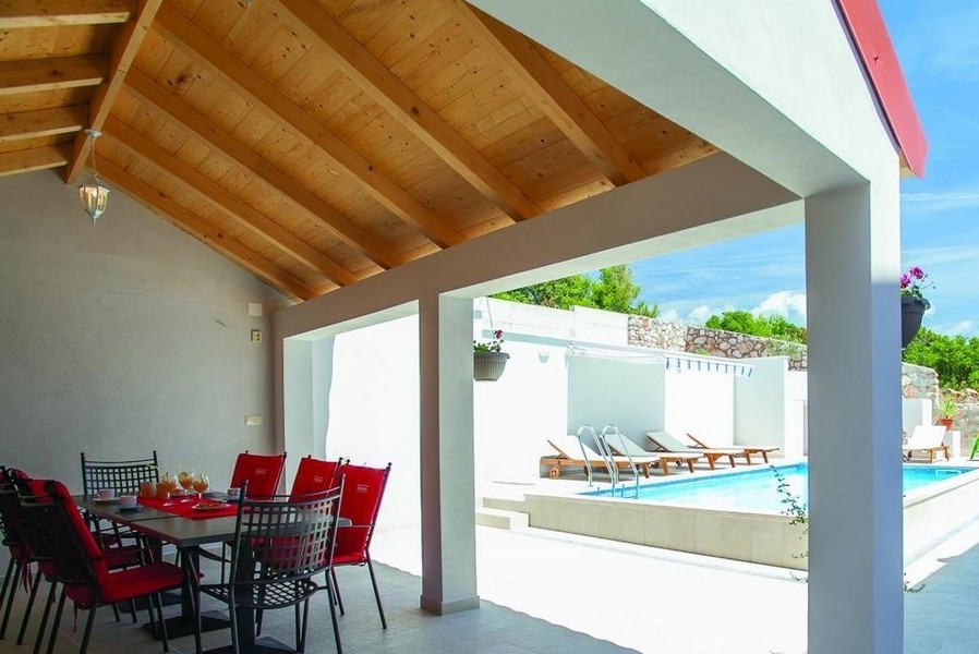 Krytý jedálenský kút a výhľad na bazén.