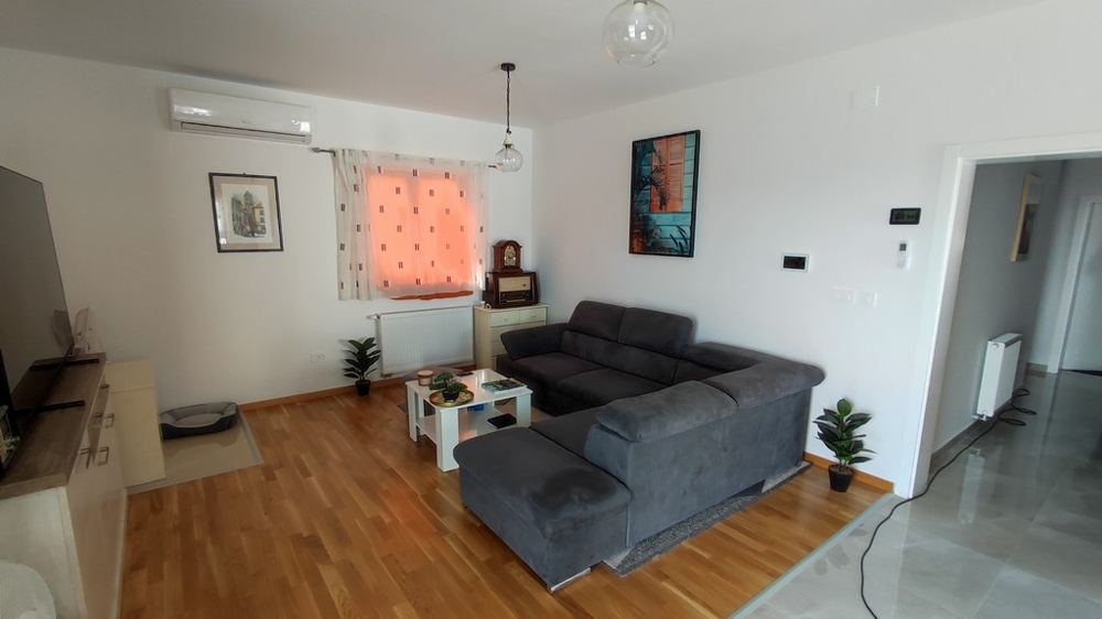 Moderná obývačka v dome na predaj vo Vodiciach v Chorvátsku s elegantným nábytkom a drevenými podlahami.