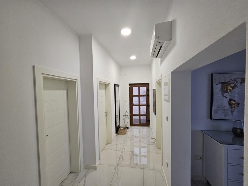 Svetlá a vzdušná chodba s lesklými podlahami v prímorskom bytovom dome v Chorvátsku