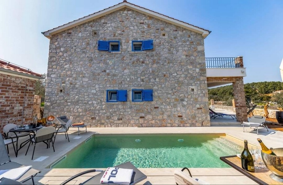 Pohľad zozadu na chorvátsku kamennú vilu na predaj s vlastným bazénom a grilom.