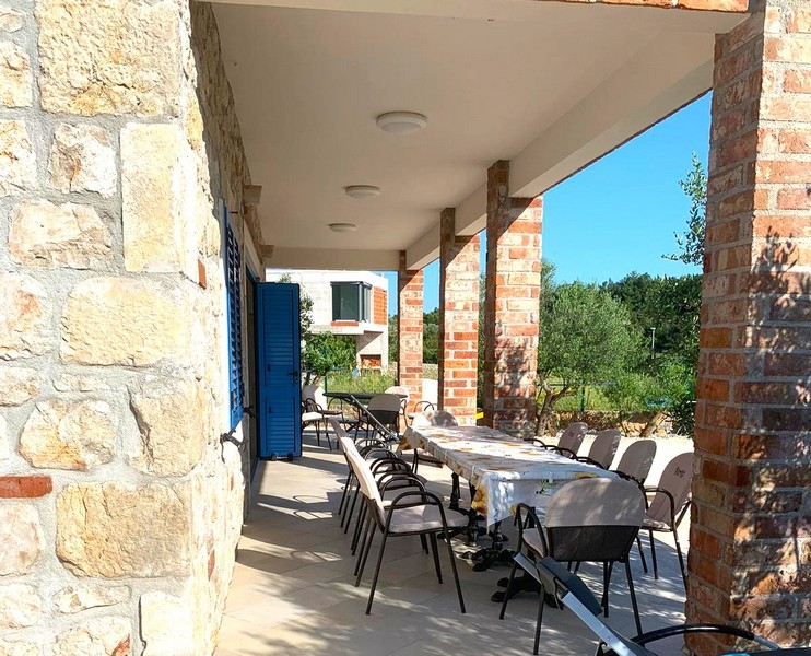 Krytý vonkajší jedálenský kút kamenného domu na predaj v Chorvátsku, ideálny na stretnutia.