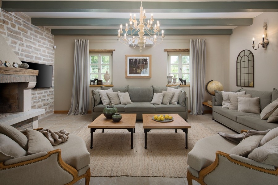 Útulná obývacia izba s krbom a elegantným nábytkom vo vile v Chorvátsku, príjemná a štýlová