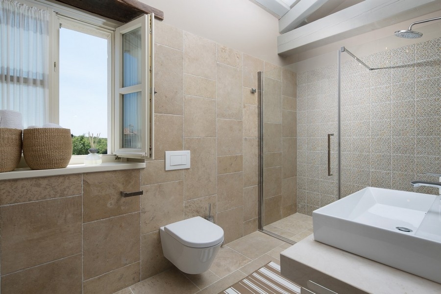 Útulná obývačka s pohovkou, kreslami a vstupom na terasu v luxusnej vile v Chorvátsku