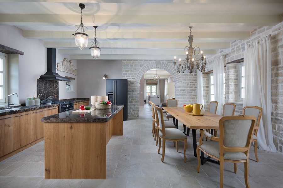 Moderná kuchyňa s dreveným ostrovom, lustrami a dlhým jedálenským stolom, pripravená na jedlo - Vila na predaj Chorvátsko H2879