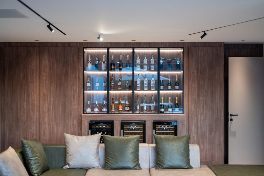 Elegantný domáci bar v luxusnej vile na predaj v Chorvátsku s dreveným obkladom a osvetlením.