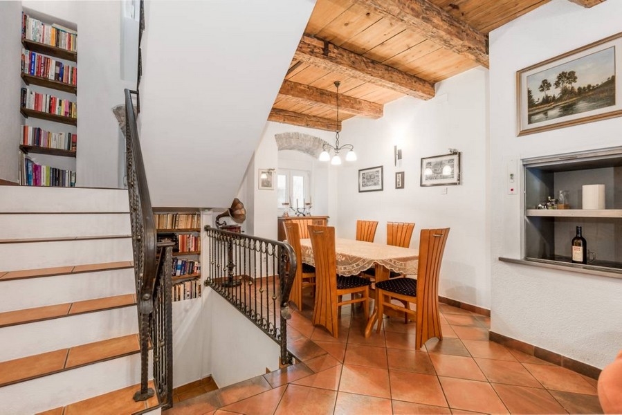 Jedáleň v interiéri chorvátskej nehnuteľnosti s drevenými trámami a schodmi