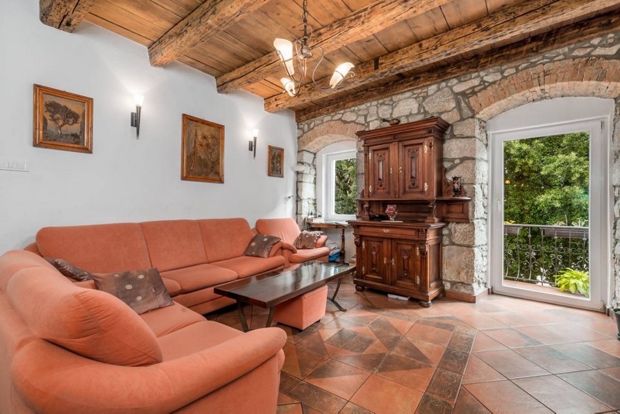 Obývacia izba nehnuteľnosti v Chorvátsku s murovaným oblúkom a prístupom na balkón