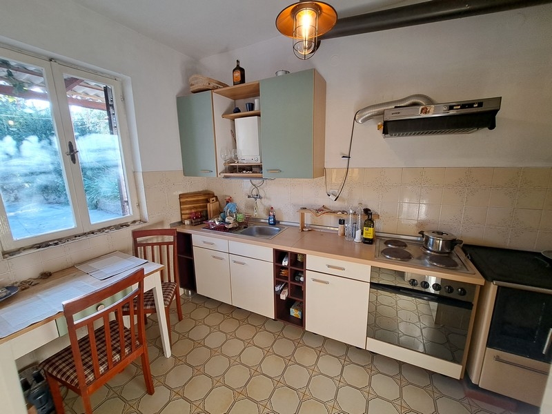 Tradičná chorvátska kuchyňa s bielymi skrinkami a oknom, súčasť ponuky nehnuteľností od Panorama Scouting.