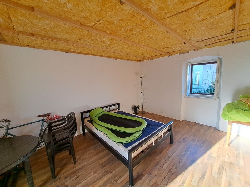 Svetlá spálňa s dreveným stropom a minimalistickým dekorom v nehnuteľnosti v Chorvátsku, dostupná cez Panorama Scouting.