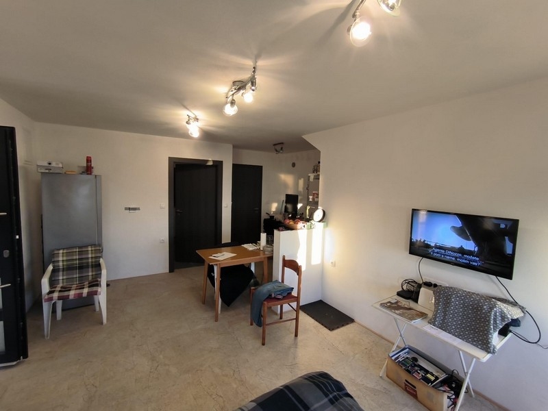 Iný pohľad na obytný priestor v nehnuteľnosti v Chorvátsku, s pohľadom na vchodové dvere a televízor