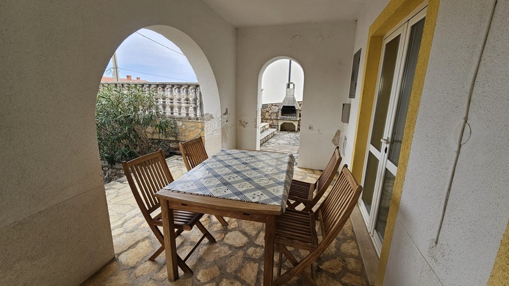 Krytá vonkajšia terasa s jedálenským stolom v dome na predaj v Karlobagu