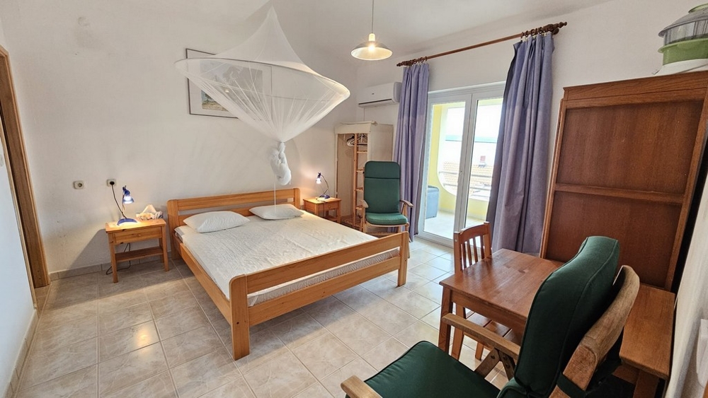 Spálňa s veľkou posteľou a prístupom na balkón v dome na predaj v Karlobagu