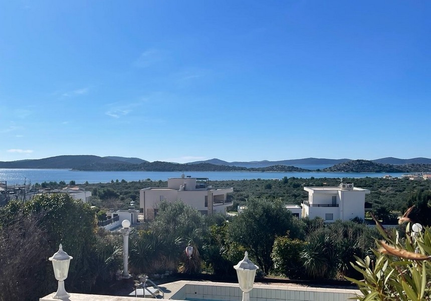 Široký uhol pohľadu na bazén a vilu s výhľadom na more v diaľke v Chorvátsku