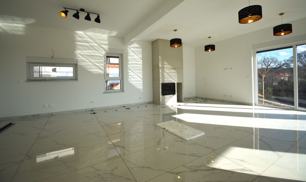 Slnečná obývacia izba s krbom a oknom v modernej vile na ostrove Krk.