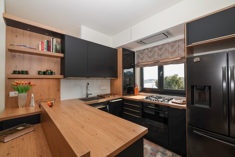 Vnútorný pohľad na modernú kuchyňu vo vile na predaj na Ugljane s drevenými prvkami a výhľadom na more.