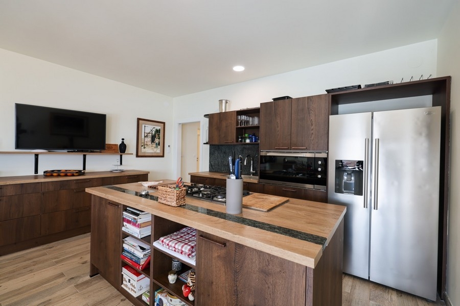 Druhá kuchynská linka s drevenými čelami skriniek a modernými spotrebičmi vo vile na predaj na ostrove Ugljan