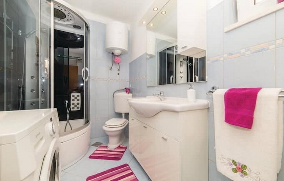 Kúpeľňa so sprchovacím kútom a práčkou v bytovom dome v Kaštel Lukšić, Chorvátsko