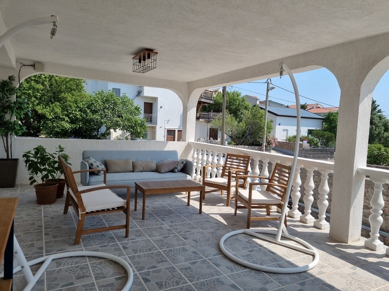 Krytá vonkajšia terasa s posedením v bytovom dome na predaj v Karlobagu, Chorvátsko.