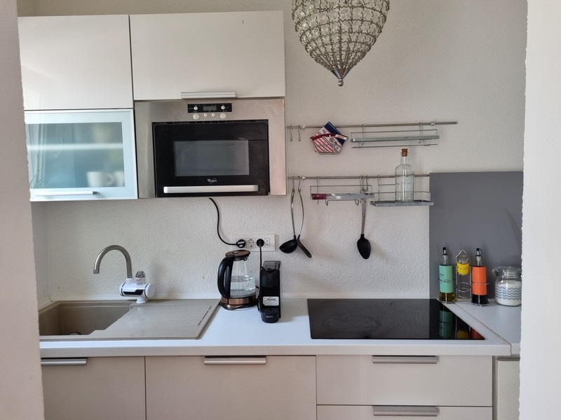 Moderná kuchyňa v interiéri bytového domu v chorvátskom Karlobagu s kuchynskými spotrebičmi a pracovnými plochami.