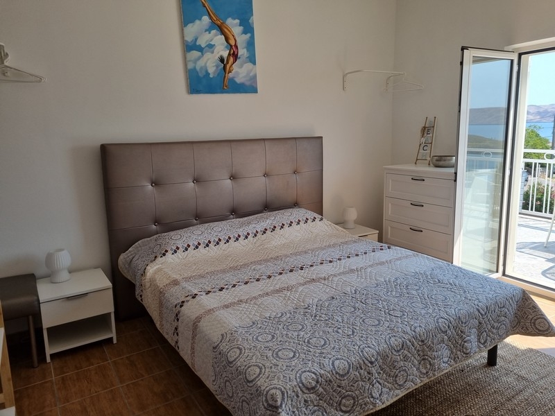 Dvojposteľová izba s umeleckým dielom na stene v bytovom dome na predaj v Karlobagu, Chorvátsko.