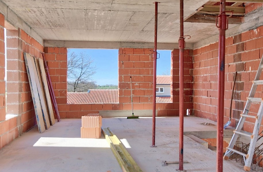 Vnútorný pohľad na rozostavaný dvojdom s výhľadom von cez veľký otvor