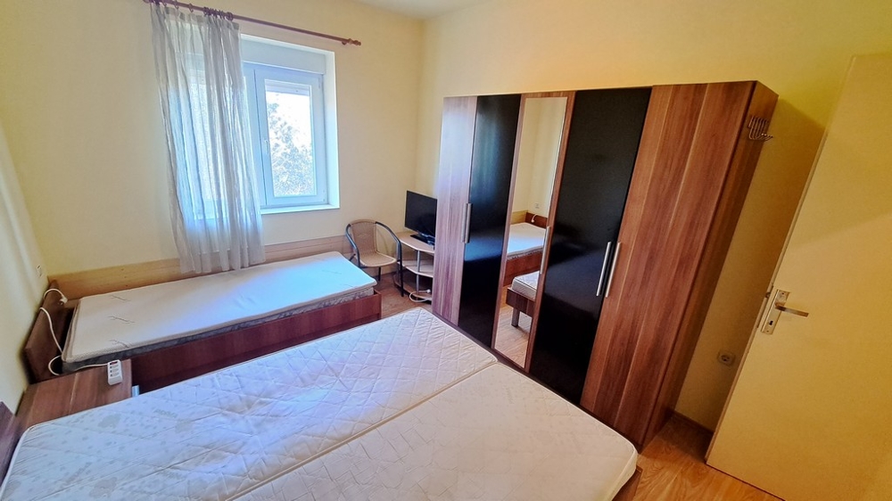 Priestranná spálňa s veľkou posteľou a pracovným priestorom, ktorá je súčasťou prímorskej nehnuteľnosti v Chorvátsku