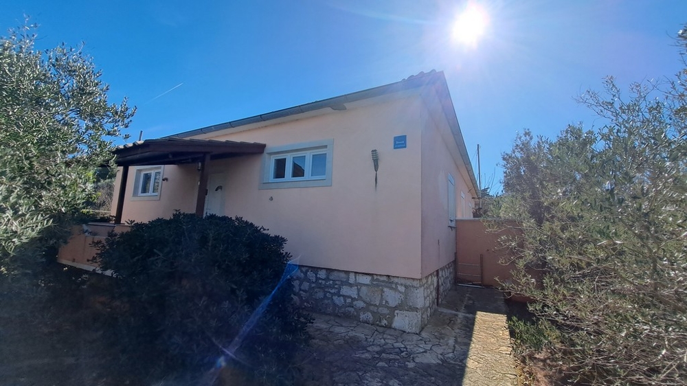 Pohľad na stranu domu obklopeného stredomorskými rastlinami, prímorská nehnuteľnosť v Chorvátsku