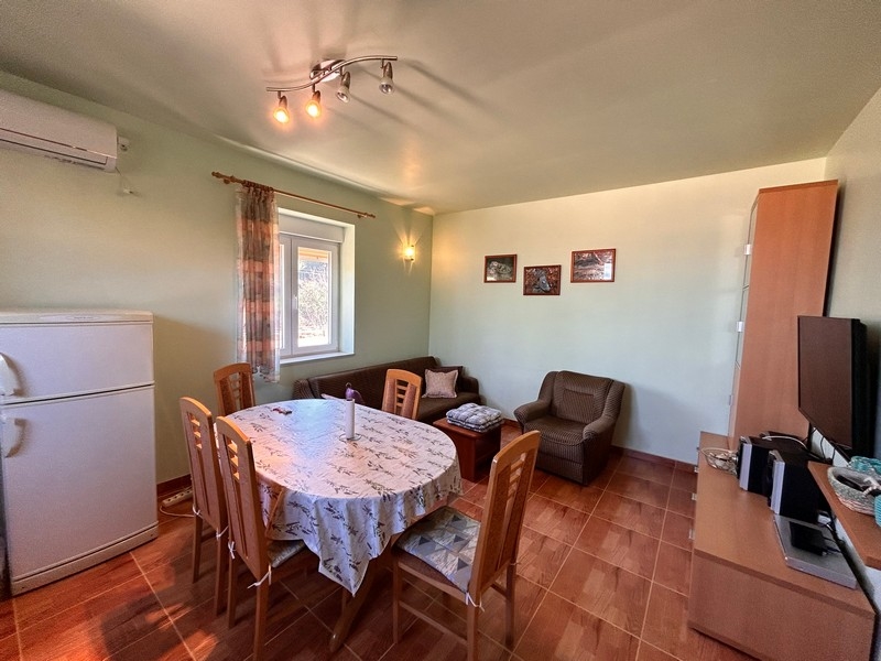 Obývacia izba s jedálenským stolom a kuchynským vybavením, vo vnútri časti prímorskej nehnuteľnosti v Chorvátsku