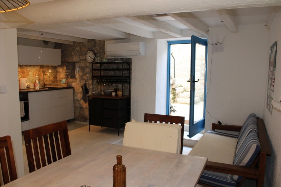 Vnútorný pohľad na kamenný dom v Murteri, obývacia izba a jedálenský kút.