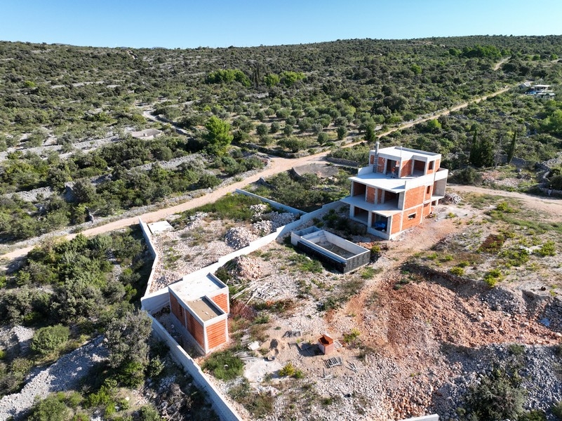 Bočný pohľad na dvojposchodovú vilu s výhľadom na more v Chorvátsku za súmraku