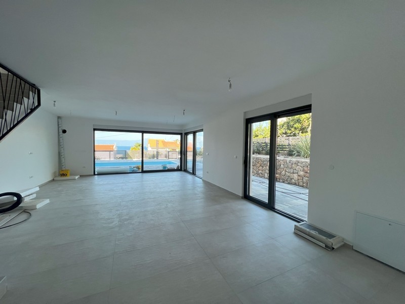 Obytná časť s jasným výhľadom von a otvoreným schodiskom, charakteristická pre moderné nehnuteľnosti v Chorvátsku.