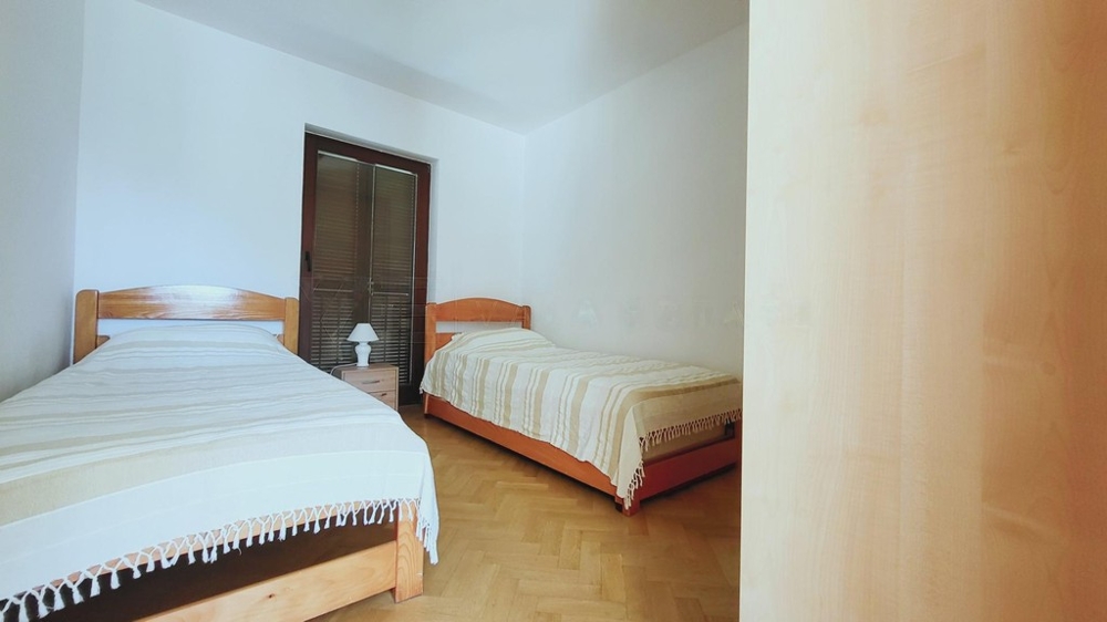 Spálňa s dvoma posteľami a parketovou podlahou