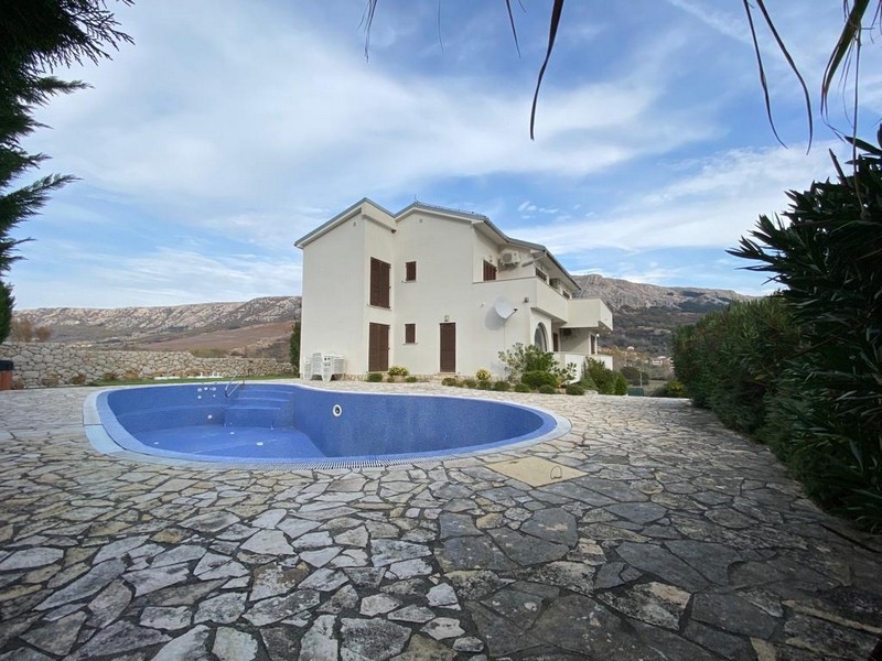 Vonkajší pohľad na biely dom s okrúhlym bazénom a kamennou cestou, chorvátska nehnuteľnosť