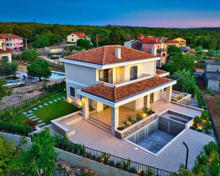 Nehnuteľnosť na ostrove Krk obklopená zeleňou pri západe slnka s osvetlenou záhradou