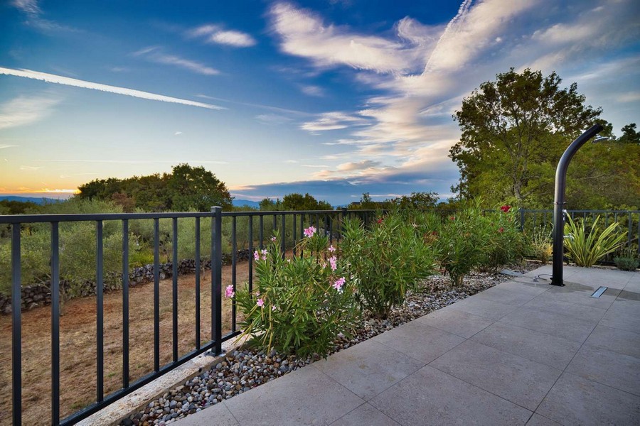 Dobre udržiavaná záhrada a prírodné okolie nehnuteľnosti na ostrove Krk s výhľadom na more v diaľke