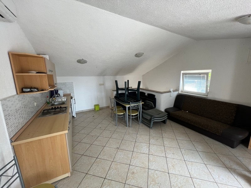 Priestranná podkrovná obývacia izba s kuchynským kútom, súčasť nehnuteľnosti na ostrove Krk.