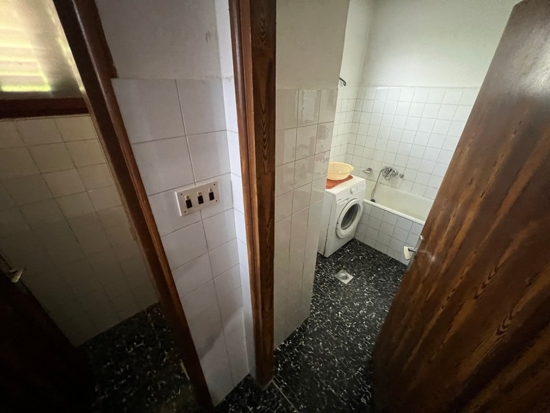 Jednoduchá kúpeľňa s práčkou a toaletou ukazuje vybavenie nehnuteľnosti na ostrove Krk.