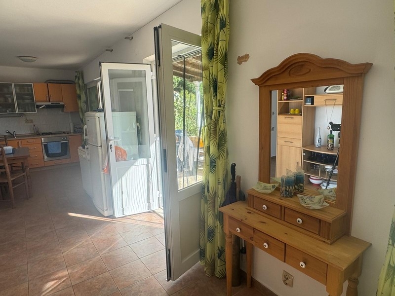 Pohľad cez presklené dvere na terasu prímorskej vily s kuchynským kútom, polostrov Pelješac