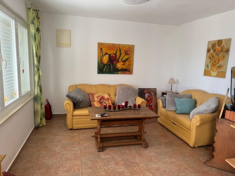 Priestranná obývacia izba so žltými pohovkami a dekoratívnymi maľbami v prímorskej vile na polostrove Pelješac