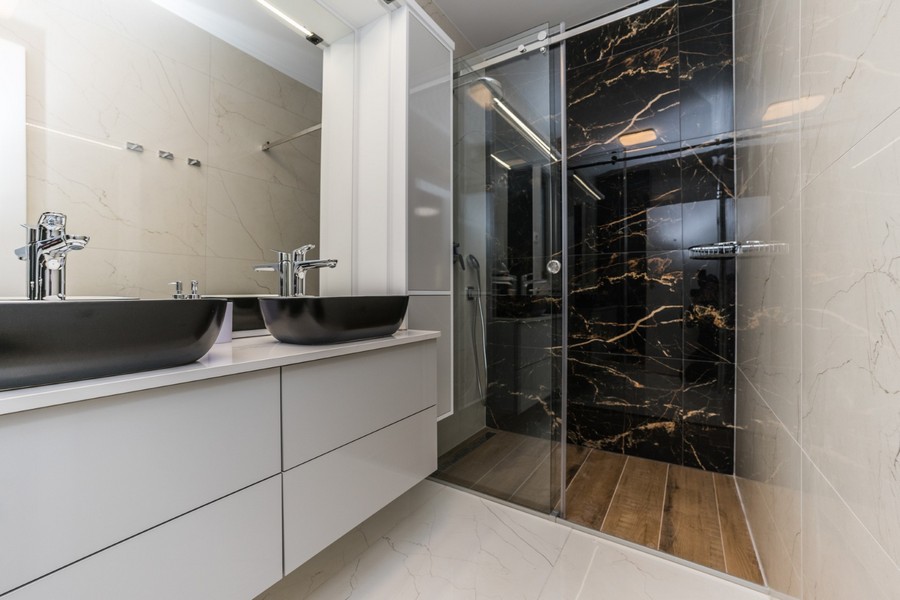 Moderná kúpeľňa s dvojitým umývadlom a priestranným sprchovacím kútom v tejto nádhernej chorvátskej nehnuteľnosti.