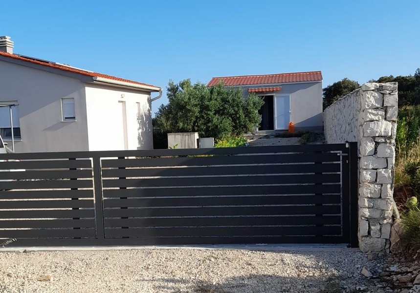 Jedálenský kút so stolom a stoličkami vedľa kuchyne s výhľadom na more cez sklenené dvere.