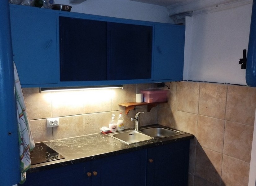 Kompaktná kuchyňa s modrými skrinkami, ideálna pre tých, ktorí si chcú kúpiť dom v Chorvátsku.