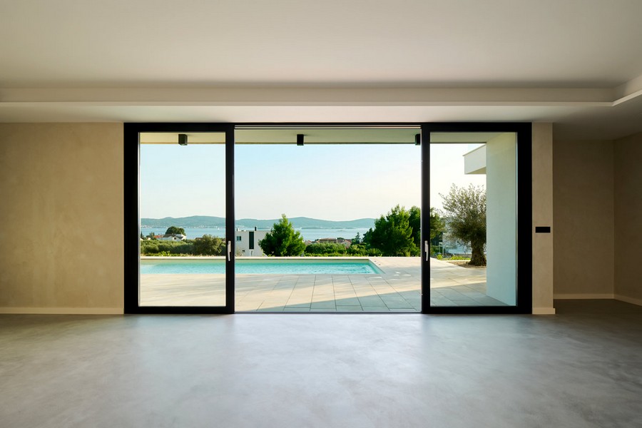 Obývacia izba s výhľadom na more a bazén.