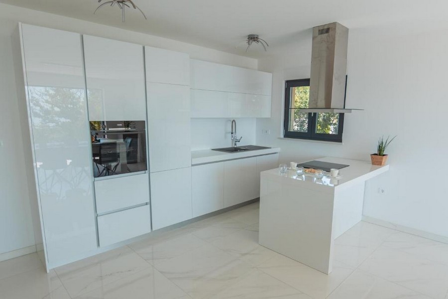 Moderná kuchyňa s bielymi skrinkami a stredovým ostrovčekom